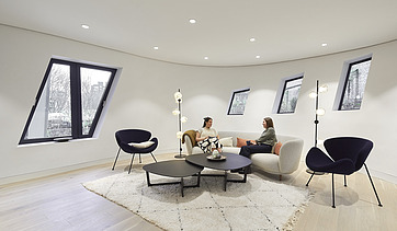 Photo of an interior. Two women are sitting on a light-colored couch.