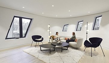 Photo of an interior. Two women are sitting on a light-colored couch.