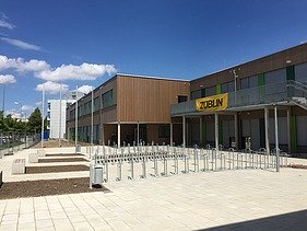 Photo of the entrance area of a school. You can see part of the wooden building.