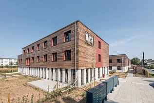 Foto des Studentenwohnheimes in Golm. Man sieht zwei Holzgebäude.