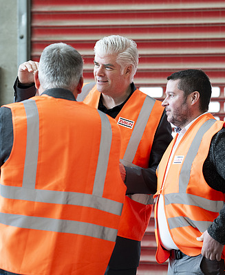 Three men in orange high-visibility waistcoats. Stefan Kratochwill in the centre.