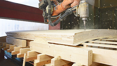 Foto eines Roboters, der ein LENO Brettsperrholzelement verbindet.