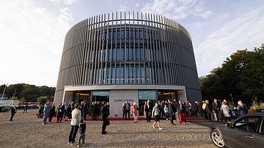 Photo of the Globe Theater in Coburg on opening day. You can see a round building made of wood.