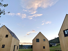 Foto des möblierten Wohnraums des Chalets Engel in Baiersbronn. Zu sehen sind drei Gebäude aus Holz.