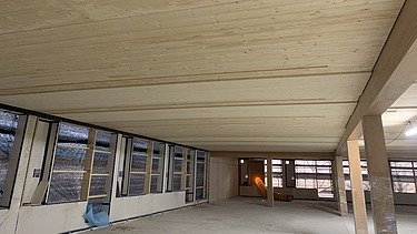 Photo of the shell of the Paul-Klee-Gymnasium in Gersthofen. You can see a wooden ceiling from below.