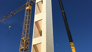 Photo of a wooden elevator shaft during crane assembly.