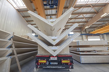 Foto eines LKW-Aufliegers, der drei LENO-Brettsperrholzelemente in V-Form geladen hat.