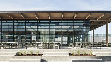 Exterior photo of the Viessmann staff restaurant in Allendorf: A building with many glass surfaces and a flat roof can be seen.