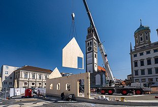 Photo of the NEXT500 pavilion on Augsburg's market square. You can see the assembly of the LENO elements.