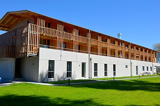 Photo of the yacht club clubhouse in Prien am Chiemsee. You can see a modern wooden building.