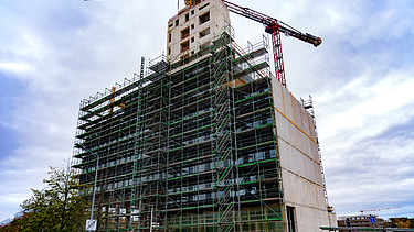 Foto der Montage des UmweltHauses in Nürnberg. Man sieht einen Rohbau aus Holz.