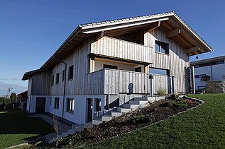 Photo of a residential building made of LENO cross-laminated timber with a timber rendered façade.