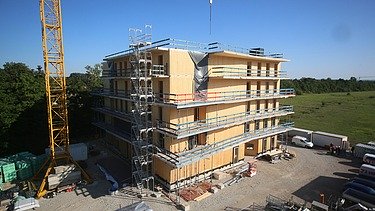 Foto eines mehrgeschossigen Holzbaus während der Montage.