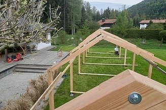 Fasteners from ZÜBLIN Timber. MGA foundations; climbing frame Photo of an MGA climbing scaffold from ZÜBLIN Timber being installed on a green lawn.