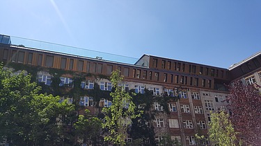 Photo of the wooden extension to the Metropolitan School Berlin. You can see a large multi-storey building.