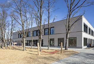 Außenaufnahme der Vinzenz-Pallotti-Schule in Friedberg. Man sieht ein großes, weißes Gebäude mit Flachdach.