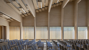 Photo of the interior seating of the Tau Kirke in Norway. You can see the wooden skeleton structure of the ceiling and wooden elements on the wall.