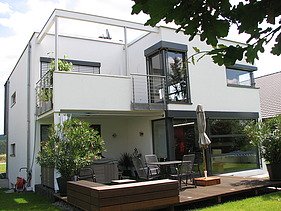 Foto eines kubischen Wohnhauses aus Holz mit Putzfassade. LENO-BSP.