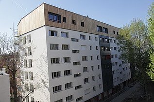 Photo of a multi-storey building with a timber extension.