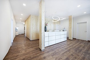 Photo of a reception area in a doctor's surgery. Many wooden surfaces can be seen. LENO-BSP.