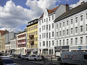Foto einer Außenaufnahme mehrerer mehrgeschossigen Gebäude an einer befahrenen Straße.  Die Aufstockung des Deutschen Chorzentrums Berlin ist zu sehen.