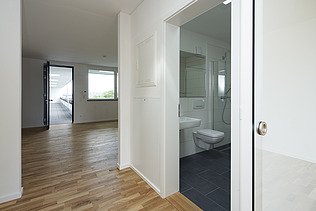 Photo of an empty apartment. You can see a living room and bathroom.