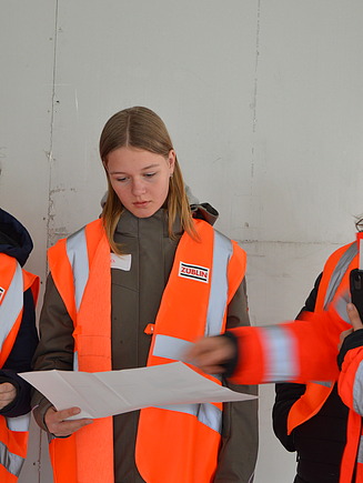 Photo of several young girls at Girls Day in Aichach. They receive information from the site manager in the building.