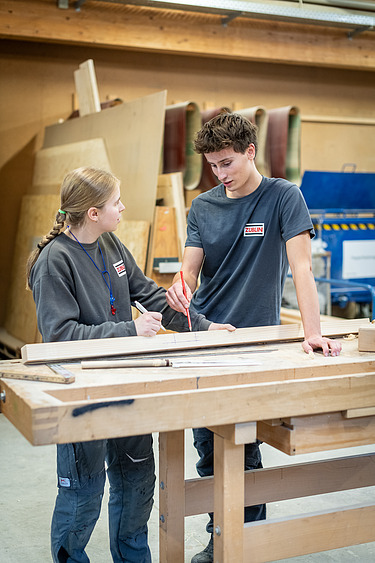 Regina works together with another carpenter.