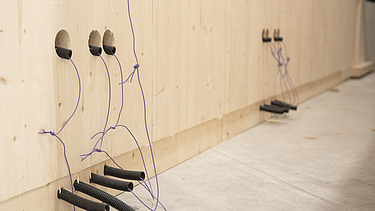 Foto einer LENO-ADD-Außenwand. Man sieht die Elektroschlitze und Rohre auf der Innenseite.