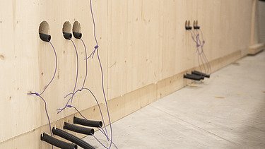 Foto einer LENO-ADD-Außenwand. Man sieht die Elektroschlitze und Rohre auf der Innenseite.
