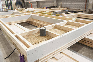 Mehrgeschossiger Holzbau bei ZÜBLIN Timber. Serielle LENO-ADD-Elemente Foto eines LENO-ADD-Holzelements in der Produktionshalle von ZÜBLIN Timber.