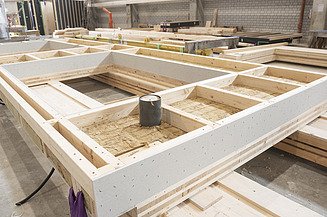Mehrgeschossiger Holzbau bei ZÜBLIN Timber. Serielle LENO-ADD-Elemente Foto eines LENO-ADD-Holzelements in der Produktionshalle von ZÜBLIN Timber.
