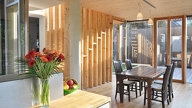 Foto eines Holzhauses mit Flachdach. LENO-BSP. Detailbild Esszimmer.