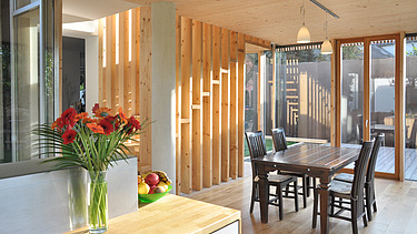 Photo of a timber house with flat roof. LENO-BSP. Detailed picture of dining room.