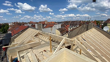 Foto einer Aufstockung aus Holz. Man sieht einen Dachstuhl aus Holz.