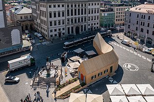 Luftaufnahme des geschwungenen Holzpavillons NEXT500 der Fuggerei Augsburg.