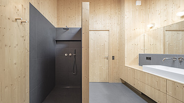 Foto eines modernen Holzhauses mit Holzfassade. Innenaufnahme Badezimmer. LENO-Holzwände.