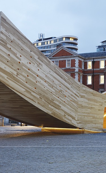 The Smile - Sculpture Design Festival London Photo of the curved wooden sculpture The Smile in London. The wooden box can be walked on and is intended to represent a smiling mouth.