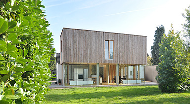 Foto eines Holzhauses mit Flachdach. LENO-BSP.