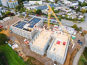 Photo of Witten University from the outside. You can see the assembly of large wooden elements from a bird's eye view